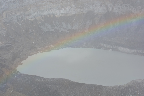 regenboog op het mistige kratermeer van Poás