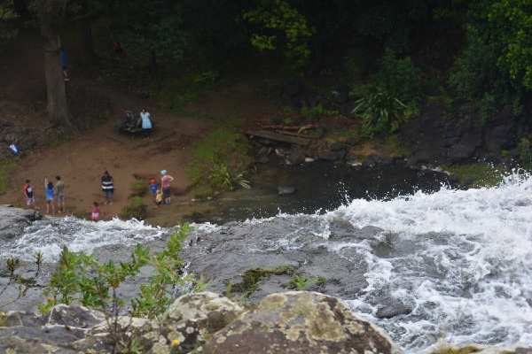 people enjoying themselves in front of the falls